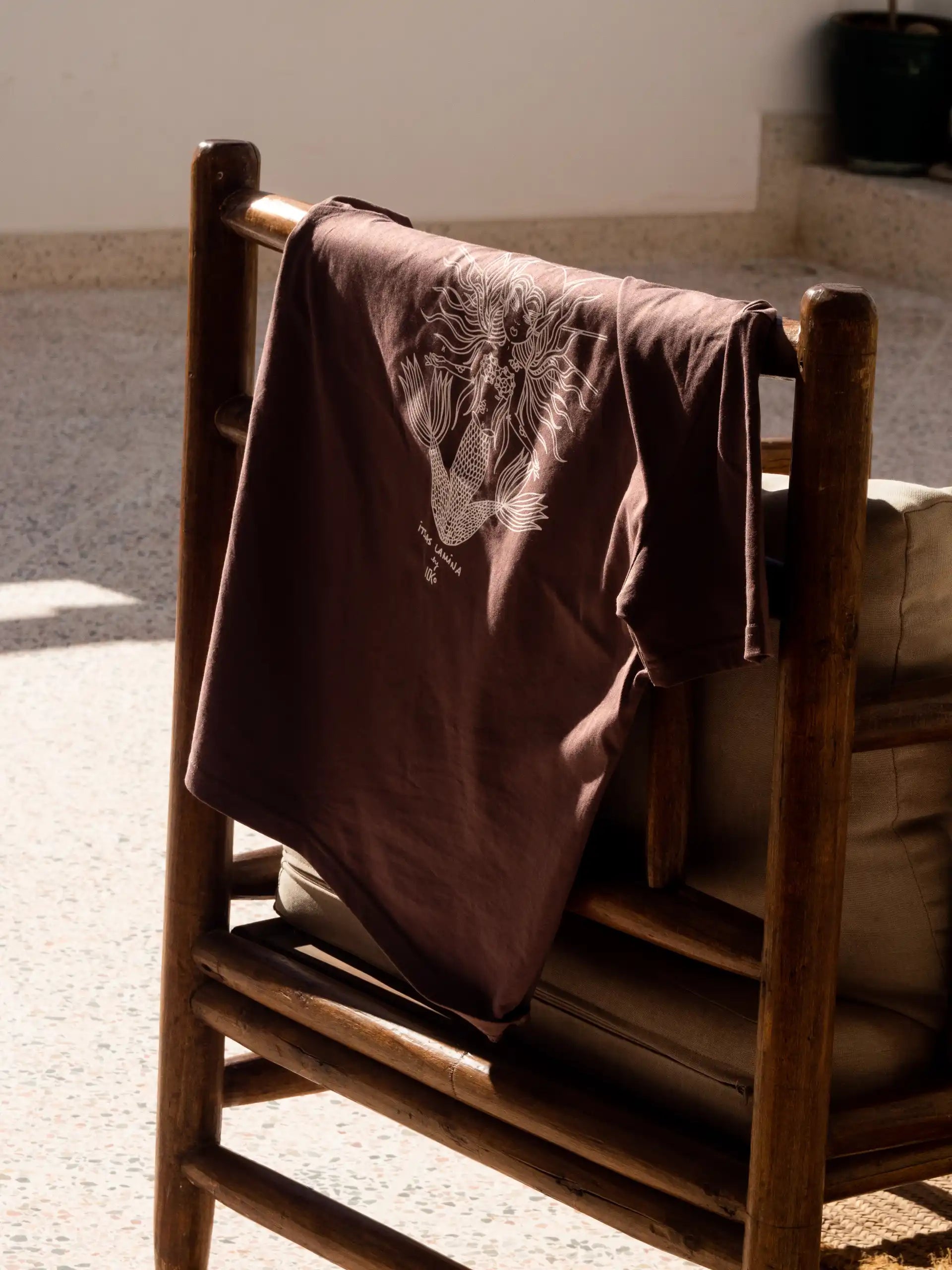 Tee-shirt basque marron sérigraphié Katxi Klothing posé sur une chaise en bois