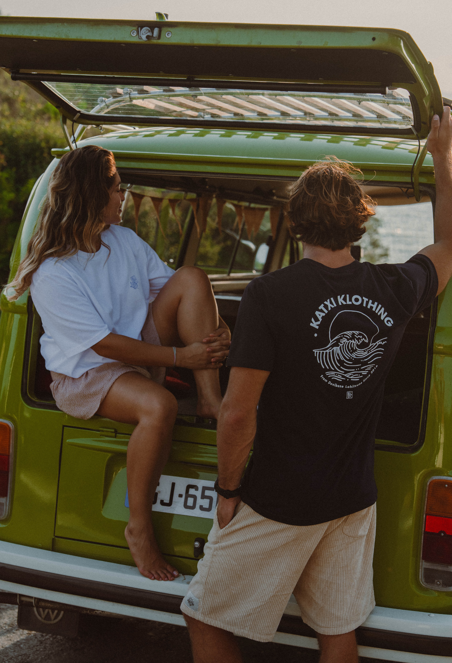 Deux personnes en tee-shirts Katxi Klothing à l'intérieur d'un van