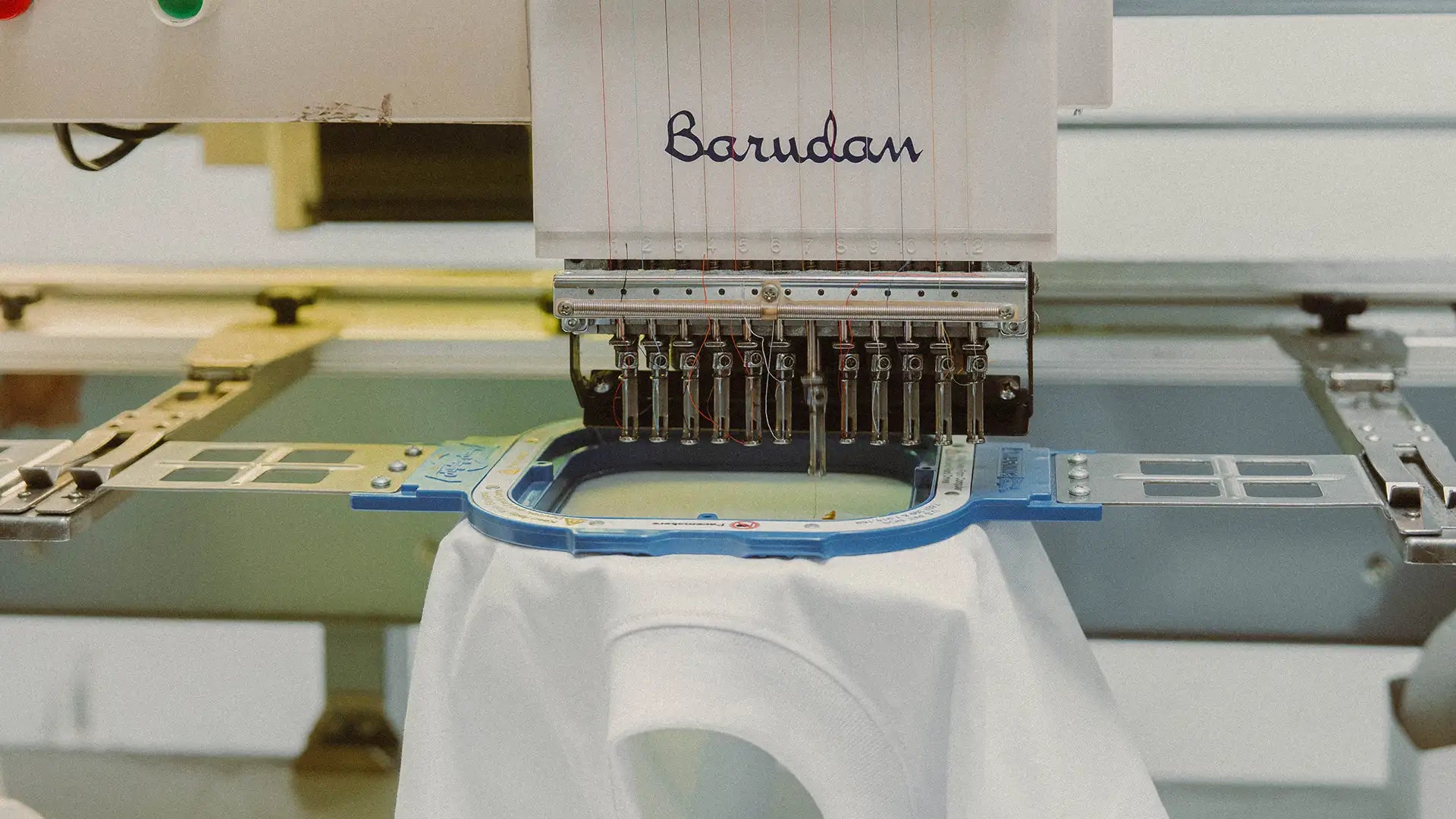 Machine à broder industrielle brodant des vêtements Katxi Klothing dans l'atelier au Pays basque