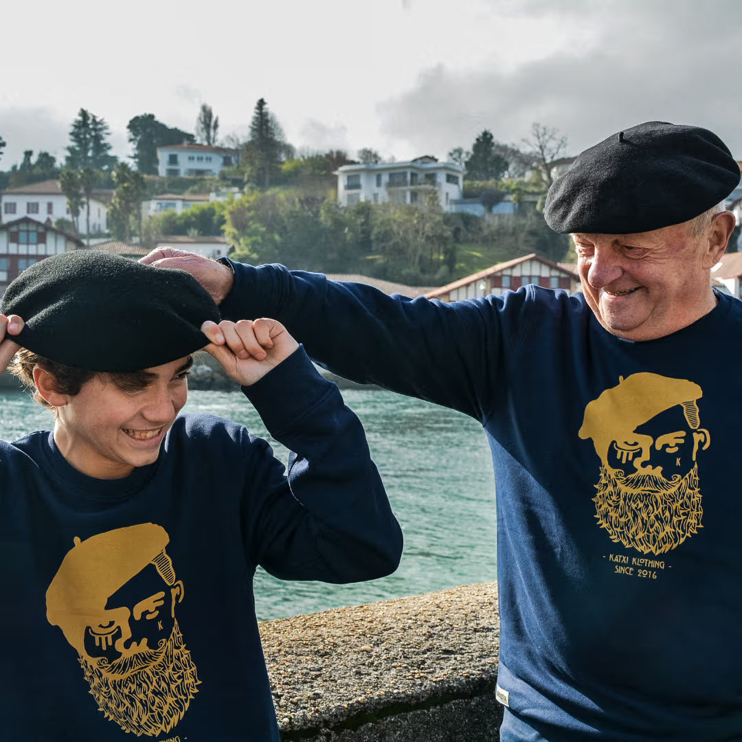 Jeune homme et son grand père en txapela et sweats Kabino Katxi Klothing face à l'océan